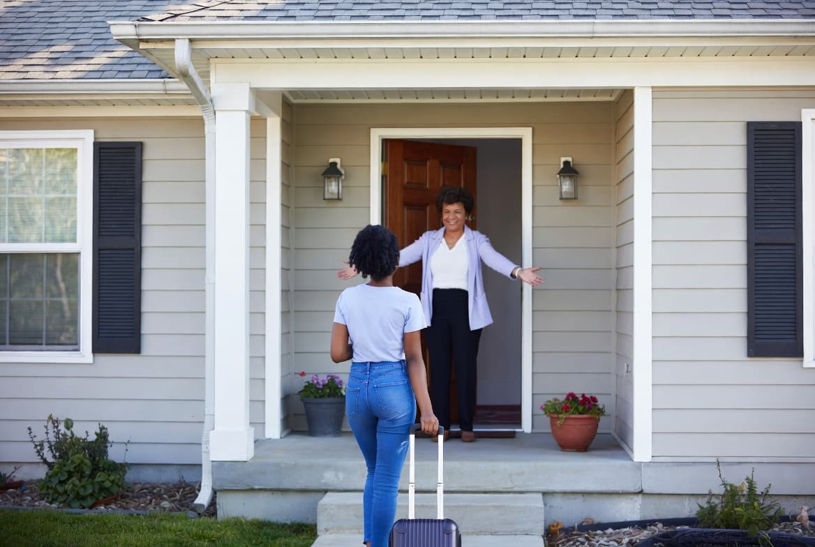 A resident is welcomed home with open arms at the front door